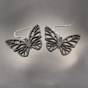 Black butterfly statement earrings featuring an intricate open-wing design with silver hooks.