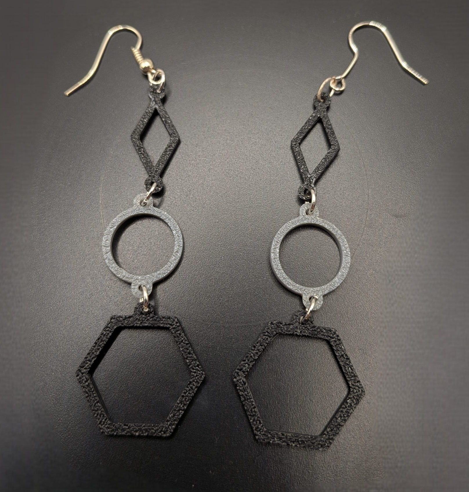 Geometric Dangle Earrings by Bitsy Boutique Black and silver geometric earrings featuring diamond, circle and hexagon shapes on silver fish hooks