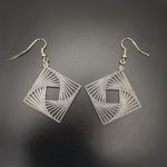 Lightweight geometric optical illusion dangle earrings featuring an intricate square spiral design with silver fish hook fastenings.