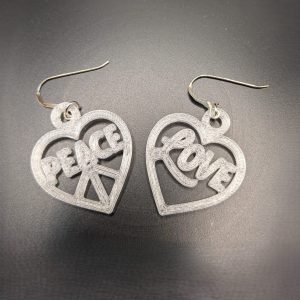 Heart-shaped Peace & Love statement earrings featuring peace and love lettering with silver hooks.